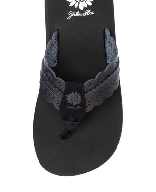 Black sandal with floral design on a white background